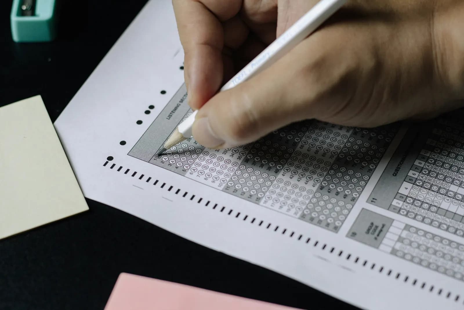 A student filling in an MCQ answer sheet with a pencil during an exam